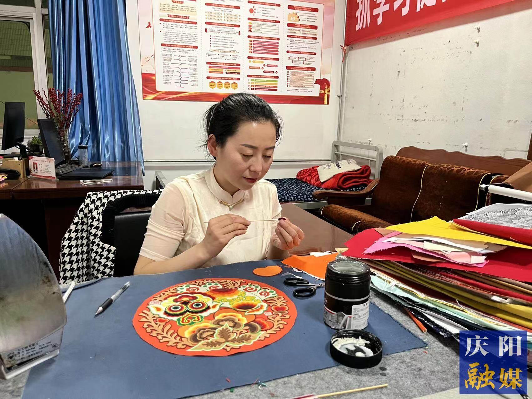李慶英正在創(chuàng)作布貼畫作品。